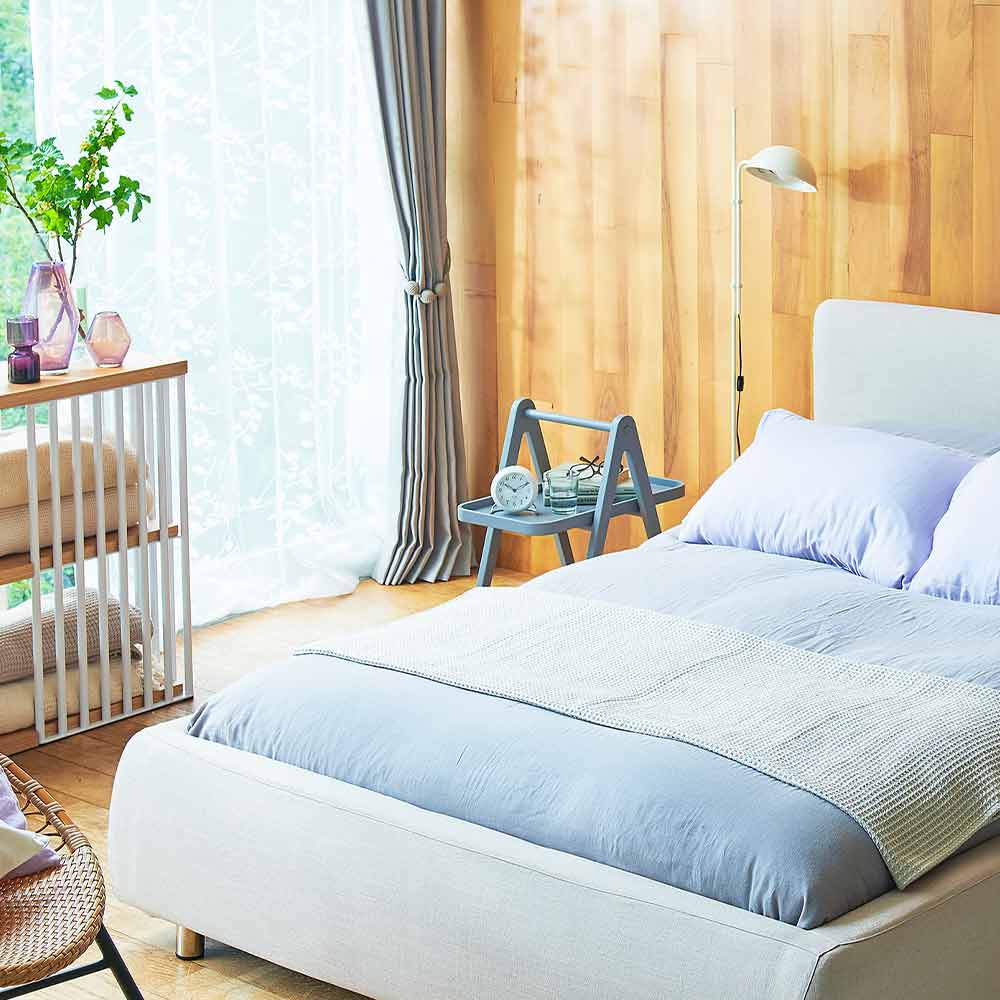 寝室イメージ画像　ベッドの左サイドにフロアスタンドがレイアウトされている。ナチュラル色・ブルー・グリーンのペールトーンでコーディネートされたナチュラル系テイスト