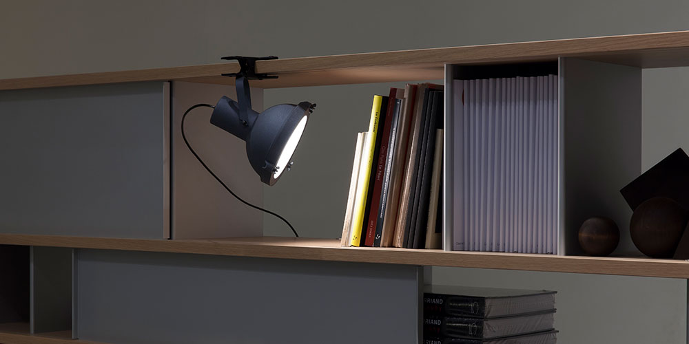 棚板2段のオープン書棚　上の棚板にクリップで挟んで上から本を照らしている画像