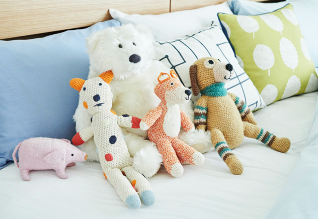 ベッドの上にぬいぐるみが並んでいる画像